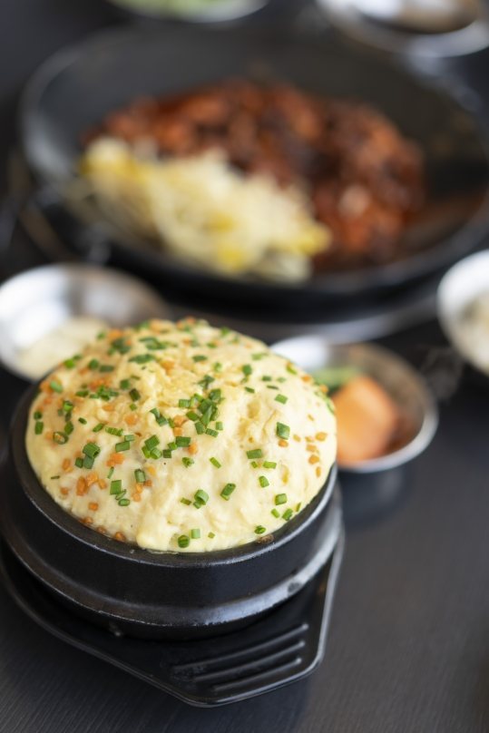 검은 그릇 위로 둥글게 부풀어 오른 폭탄계란찜